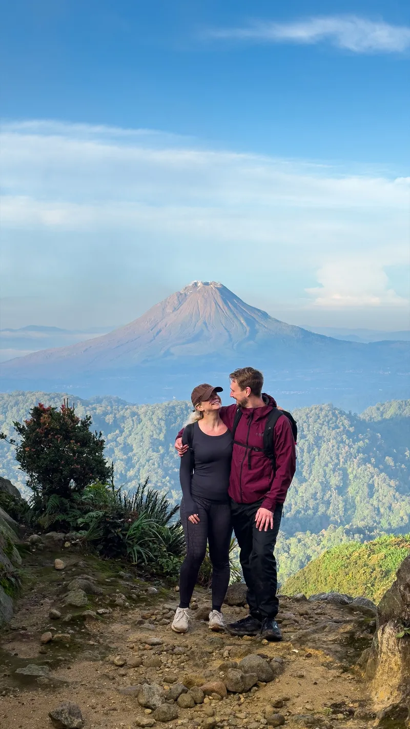 Trekkers on the jungle trail with Mount Sinabung in the distance