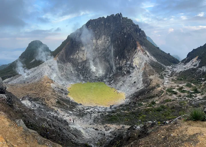Steam rising from a thermal pond inside the Mount Sibayak crater